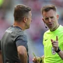 Northampton boss Jon Brady is yellow carded by referee Ross Joyce during Saturday's defeat against Latics at the DW