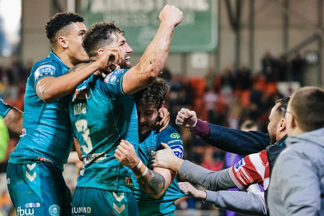 The Wigan Warriors players celebrate with the travelling fans