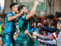 The Wigan Warriors players celebrate with the travelling fans