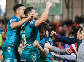 The Wigan Warriors players celebrate with the travelling fans