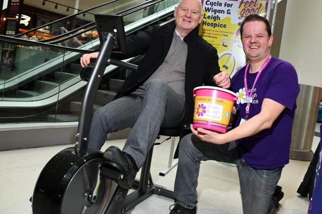 From left:  Mike Matthew, general manager at The Grand Arcade Shopping Centre, Wigan, on a static fitness bike, pictured with Chris Swinton, events and fundraising at Wigan and Leigh Hospice, as staff from the Grand Aracade and shoppers take turns to pedal a total of 2024km, part of the Feel Good February challenge, raising funds for the charity