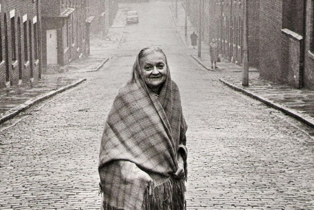Clogs echoing along the cobbled streets in the damp morning air as mill girls, pulling their shawls over their heads, hurried to work past rows of terraced houses. A memory from yesteryear...but Wigan 1967, retained many links with the past. Mrs Martha Carter, then 76, of Gilroy Street, Scholes still wore her shawl and walked down those same cobbled streets. Picture by Bill Batchelor.

