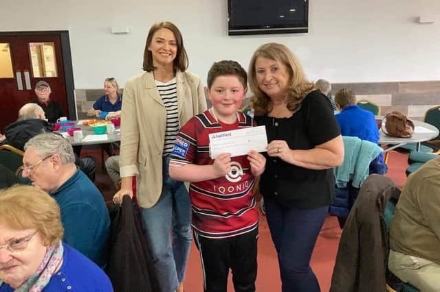 Alfie pictured holding the cheque, with Claire Taylor and Sue Metcalfe.