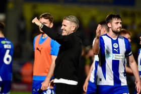 Ryan Lowe celebrates Latics' point at Burton with his players in front of the away end