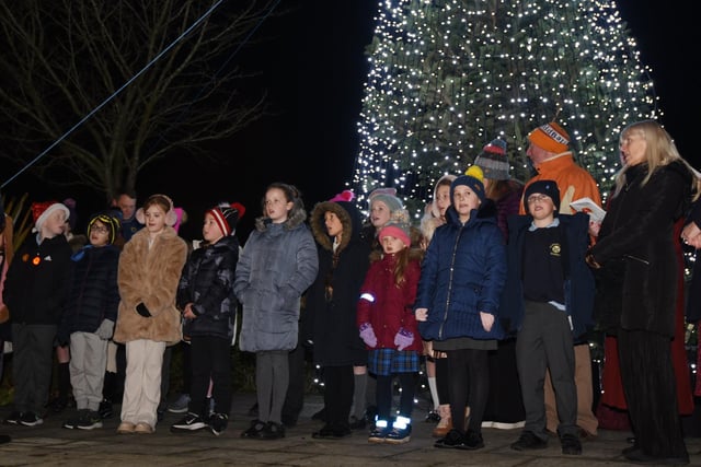 Children sing in front of the Christmas tree