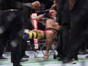 Tom Aspinall is treated in the ring after injuring his knee