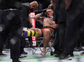 Tom Aspinall is treated in the ring after injuring his knee