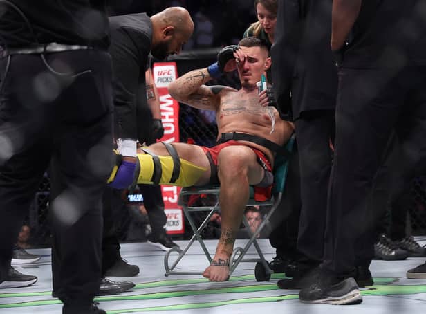 Tom Aspinall is treated in the ring after injuring his knee