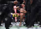 Tom Aspinall is treated in the ring after injuring his knee