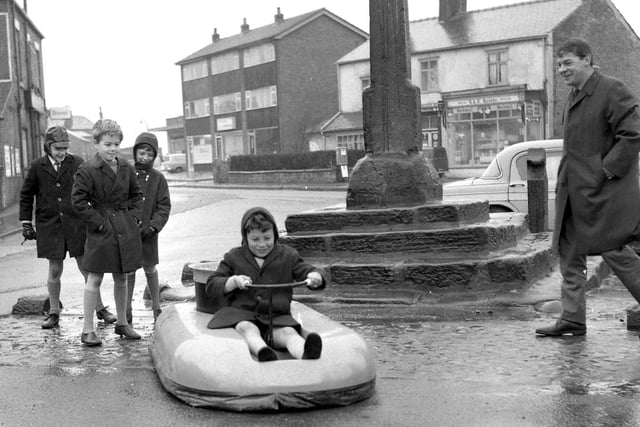 RETRO 1968 - Youngsters play with a hovercraft on the streets of Standish