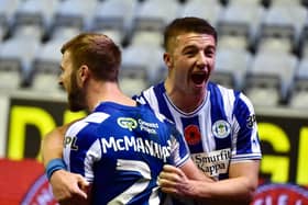 Charlie Hughes helps Callum McManaman celebrate Latics' late winner against Peterborough