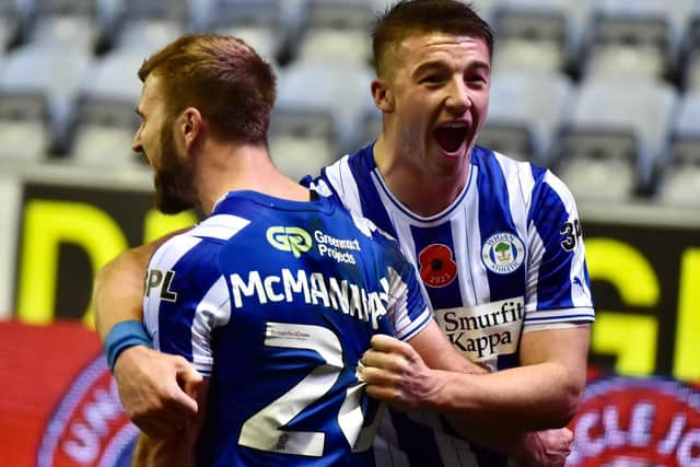 Charlie Hughes helps Callum McManaman celebrate Latics' late winner against Peterborough