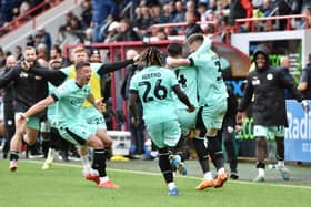 Jordan Jones is mobbed after securing Latics' 2-0 victory at Exeter