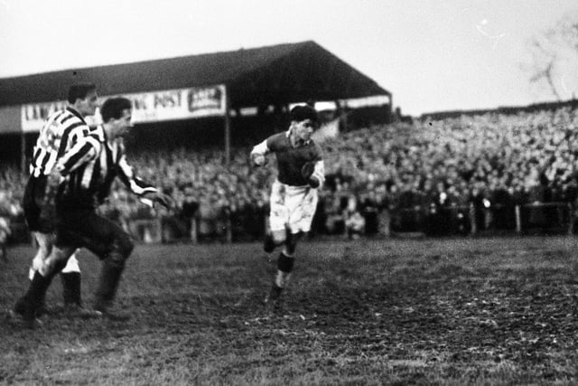 Wigan Athletic centre forward Billy Lomax heads for goal against Newcastle United.