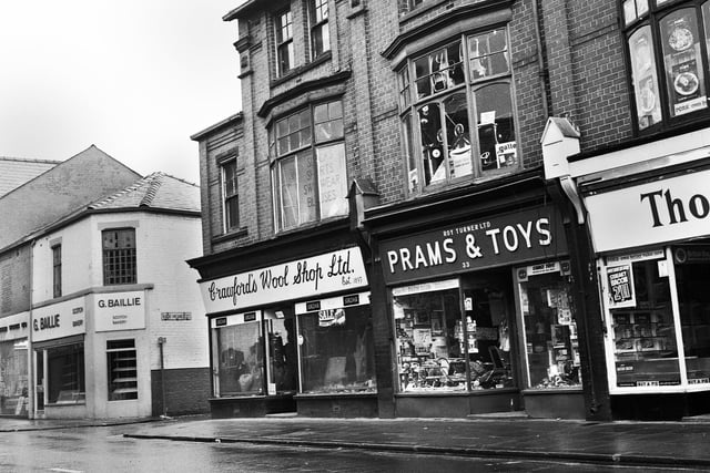 Mesnes Street, Wigan, in the 1960s with G.Baillie Scotch Bakery, Crawfords Wool Shop, Roy Turner's Prams and Toys shop and just the edge of Thornleys Pork Butchers.
