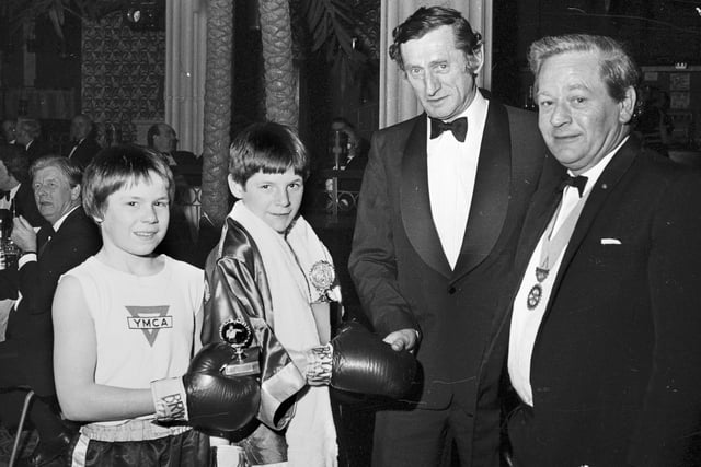 Two young competitors are presented with their trophies at a boxing tournament organised by Wigan Rotary Club at Tiffany's night club in 1977.