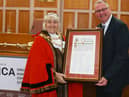 The outgoing Mayor of Wigan, Coun Marie Morgan, makes a presentation to her successor Coun Kevin Anderson