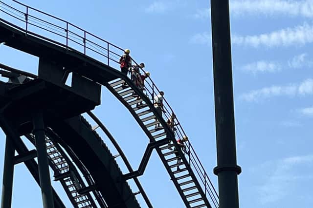 Rescue teams wearing helmets and safety ropes scaled the ride and handed stranded riders bottled water as temperatures soared to 37c at the Staffordshire theme park. Credit: @dean8001