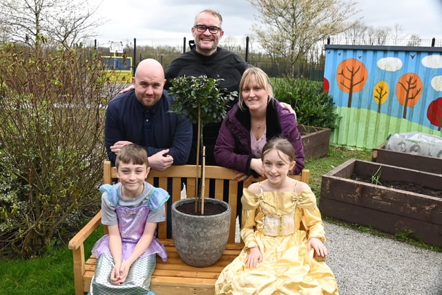 Hindley Green Community Primary School headteacher Tim Mooney, back centre, with Holly's parents Mark and Jenny Prince, brother Jack, nine, and sister Evie, 11, with a bench and holly bush in memory of Holly in the school garden