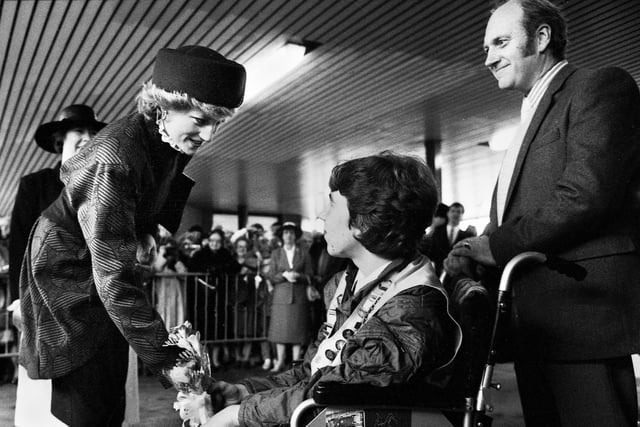 Princess Diana accepts a posy of flowers from Stephen Hooton of Orrell watched by proud dad Jim at Wigan North Western station as she and Prince Charles made their way to open a factory in Skelmersdale on Wednesday 23rd of April 1986.