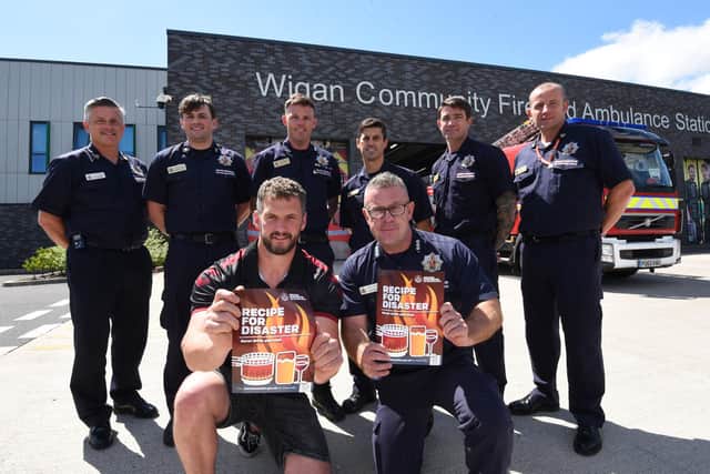 Wigan Warriors' Sean O'Loughlin and Wigan fire station commander Chris Evans, front, with firefighters Paul Farnhead, Gerry Davis, John Klieve, David Parsons, Clint Riley and Craig Pender