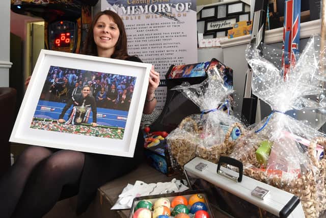 Carly Defreitas, owner of Q8 Sports bar, with some of the prizes to raise funds for the charity