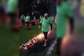 87-year-old great-grandad, Bill Woodcock  successfully crossing a bed of burning coals to cheers from the crowds