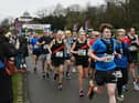 Half marathon runners stream across the start line at Mesnes Park