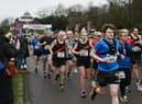 Half marathon runners stream across the start line at Mesnes Park