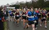 Half marathon runners stream across the start line at Mesnes Park