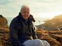 Sir David Attenborough, filming for Wild Isles series, next to Common puffins (Fratercula arctica), Skomer Island, off Pembrokeshire coast, Wales