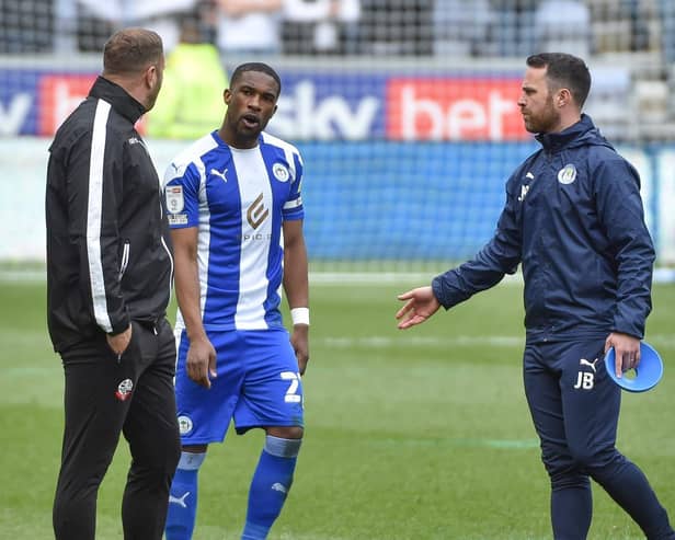 Latics skipper Tendayi Darikwa has words with Bolton boss Ian Evatt just before the second half