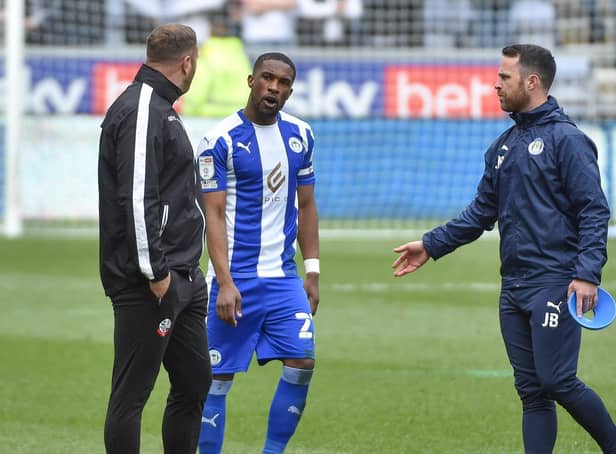 Latics skipper Tendayi Darikwa has words with Bolton boss Ian Evatt just before the second half