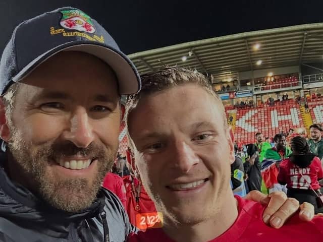 Ryan Reynolds celebrates on the pitch at Wrexham with Paul Mullin