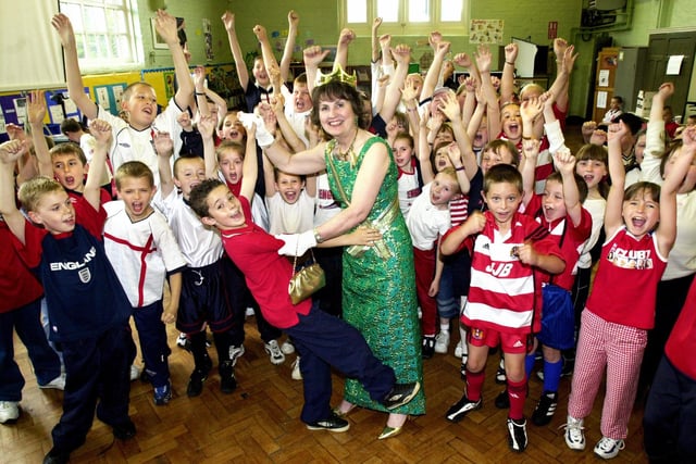 Tyan Sumner, aged 8, has a royal rumba with her majesty, alias school cleaner Margaret Bradley, at St. John's Primary School, New Springs, Queens Golden Jubilee celebrations on Thursday 30th of May 2002.