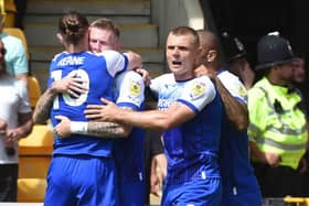 The Latics players celebrate James McClean's opening goal
