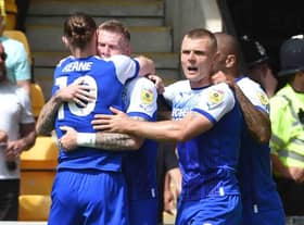 The Latics players celebrate James McClean's opening goal