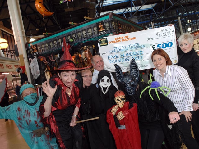 Gemma and Sophie Davies, of Scream Machine, along with Dave Clitherow, owner of the Halloween stall at Wigan Market Hall, present David Wilde, from Derian House Children's Hospice, with a donation of £500.  With them are market workers Stacey Price, Denise Johnson, Charlotte Taylor and Bronwen Roberts