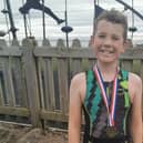 Ten-year-old Travis Horrocks celebrates completing the triathlon
