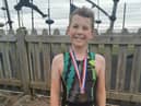 Ten-year-old Travis Horrocks celebrates completing the triathlon