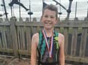 Ten-year-old Travis Horrocks celebrates completing the triathlon