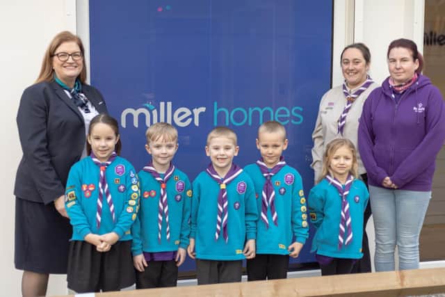 Members of the 3rd Wigan Scouts celebrate receiving a grant from Miller Homes
