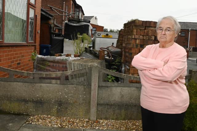 Margaret Fishwick, 82, is fed up with her neighbour's mess in both front and back gardens.