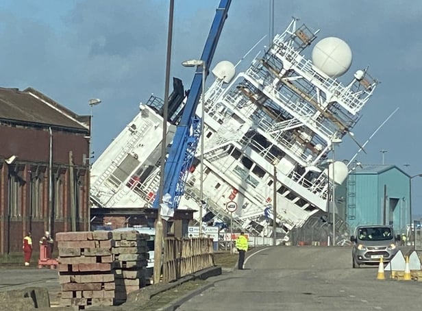 <p>A ship is currently leaning towards the docks at a worrying angle in Leith, Edinburgh. (Photo credit: @Tomafc83 on Twitter)</p>