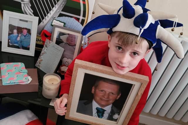Latics fan Finley McKeown with a photograph of his grandad Sam Smyth