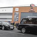 The funeral cortege of former Wigan Warriors chairman Maurice Lindsay pauses outside the DW Stadium as staff members applaud to pay their respects. The funeral was held at St Mary's Church, Standishgate, Wigan