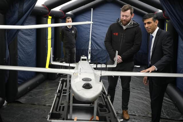 Prime Minister Rishi Sunak speaks with staff as he views a drone used for surveillance of vessels in distress, during a visit to the Home Office joint control centre in Dover