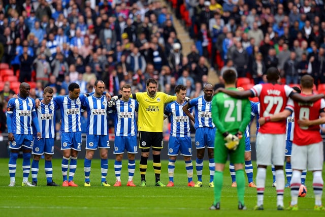 Players and officials observe a minute's silence to mark the 25th anniversary of the Hillsborough disaster prior to the FA Cup Semi-Final match between Wigan Athletic and Arsenal at Wembley Stadium on April 12, 2014 in London, England.