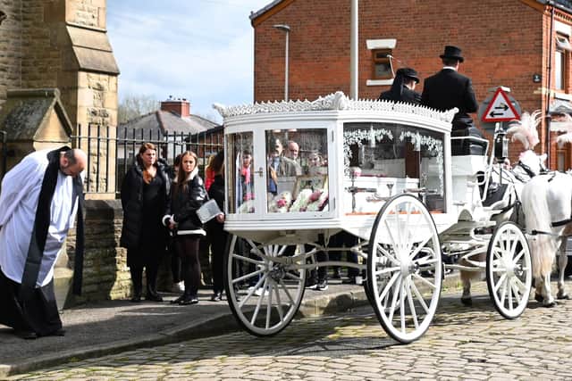 Rev John Keeley bows as a horse-drawn hearse bearing Pam Shaw arrives at Christ Church, Ince