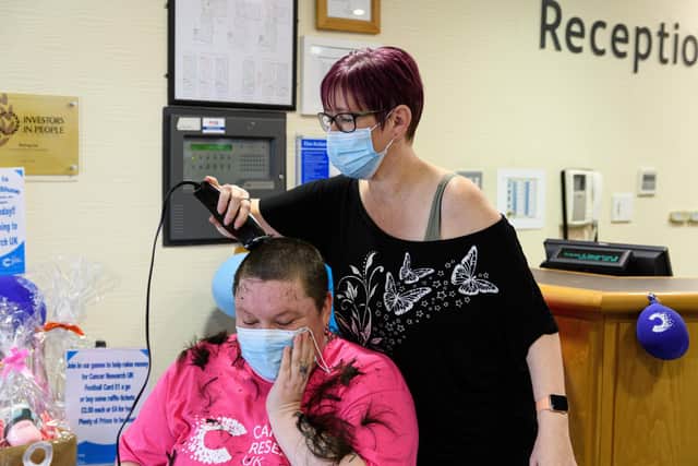 Alison Kinahan gets to work shaving Lyndsey Sohe's hair